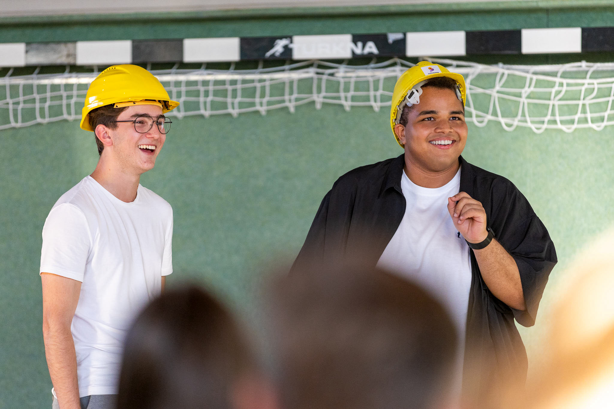Felix Hofer & Oliver Hrebejk mit Bauhelmen in einem Turnsaal